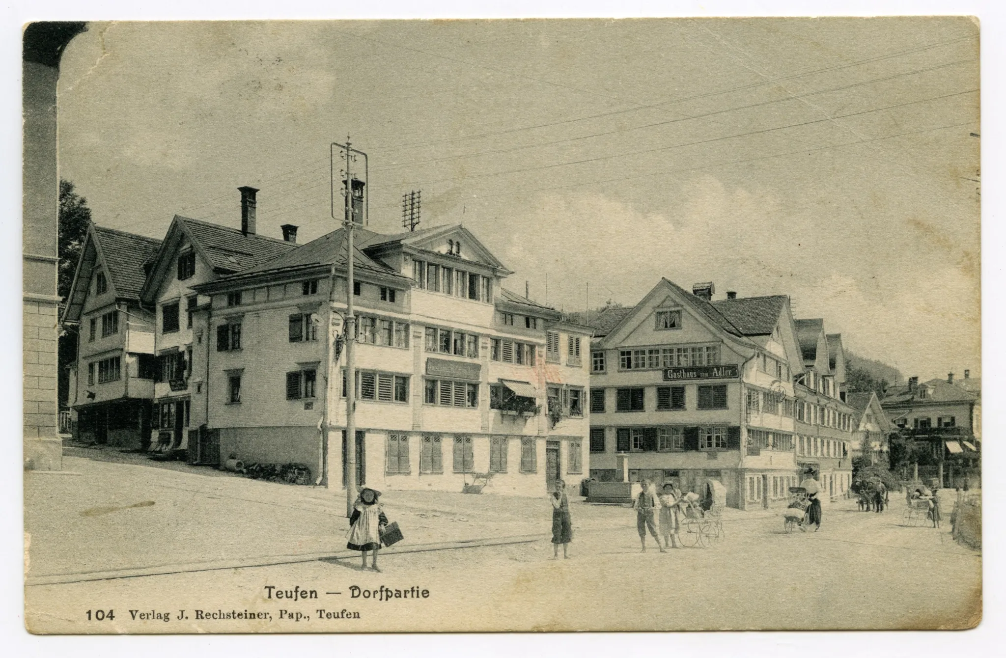 Dorfstrasse. Ecke Gemeindehaus, „Anker“, „Adler“, Blick zur Villa Roth. Posierende Kinder und Frauen mit Kinderwagen, Ochsenfuhrwerk