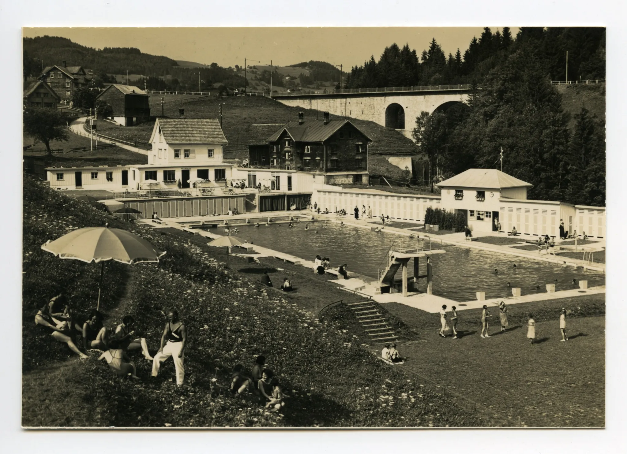mit Badegästen und alter Bahnbrücke im Hintergrund