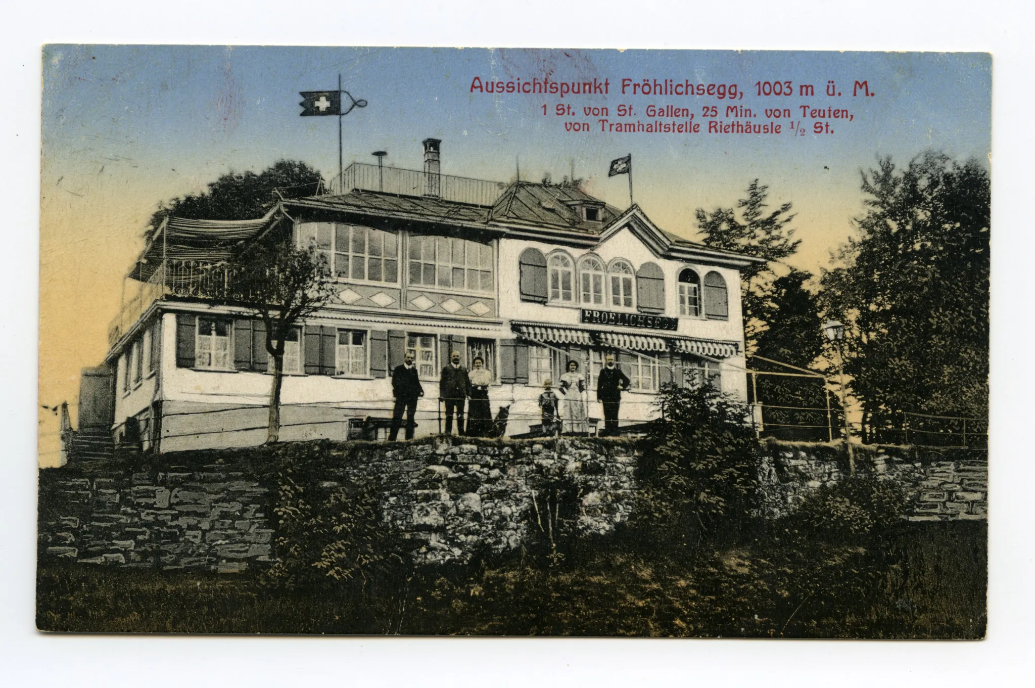 Ansicht von Süden mit Eigentümerfamilie? vor dem Haus (vgl. Hc.08-26, Motiv identisch, aber Karte schwarz-weiss und zusätzlichen Gästen auf Sitzplatz rechts)