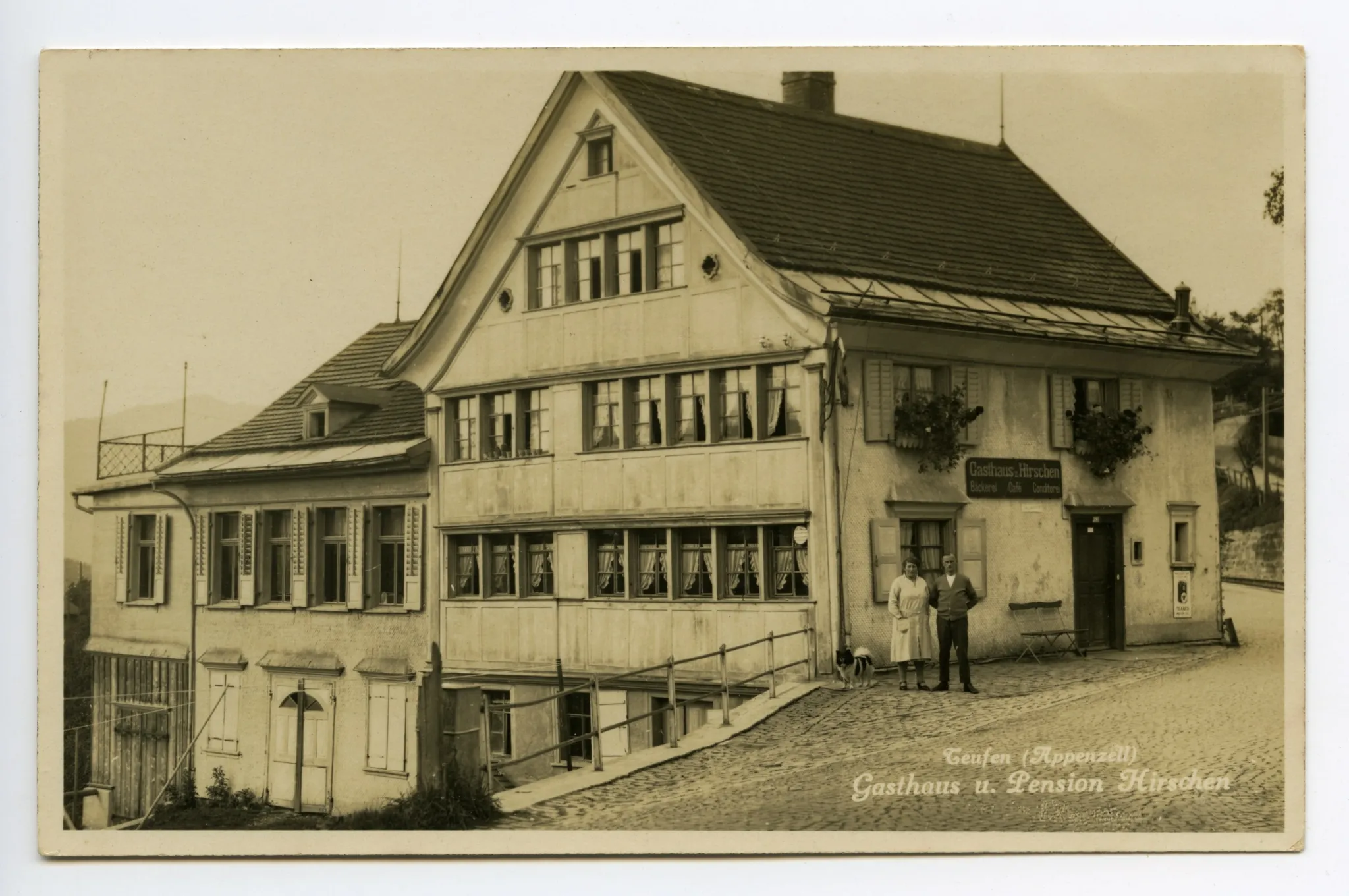 Frontansicht (vor der Verschiebung) mit Besitzerehepaar vor dem Gasthaus