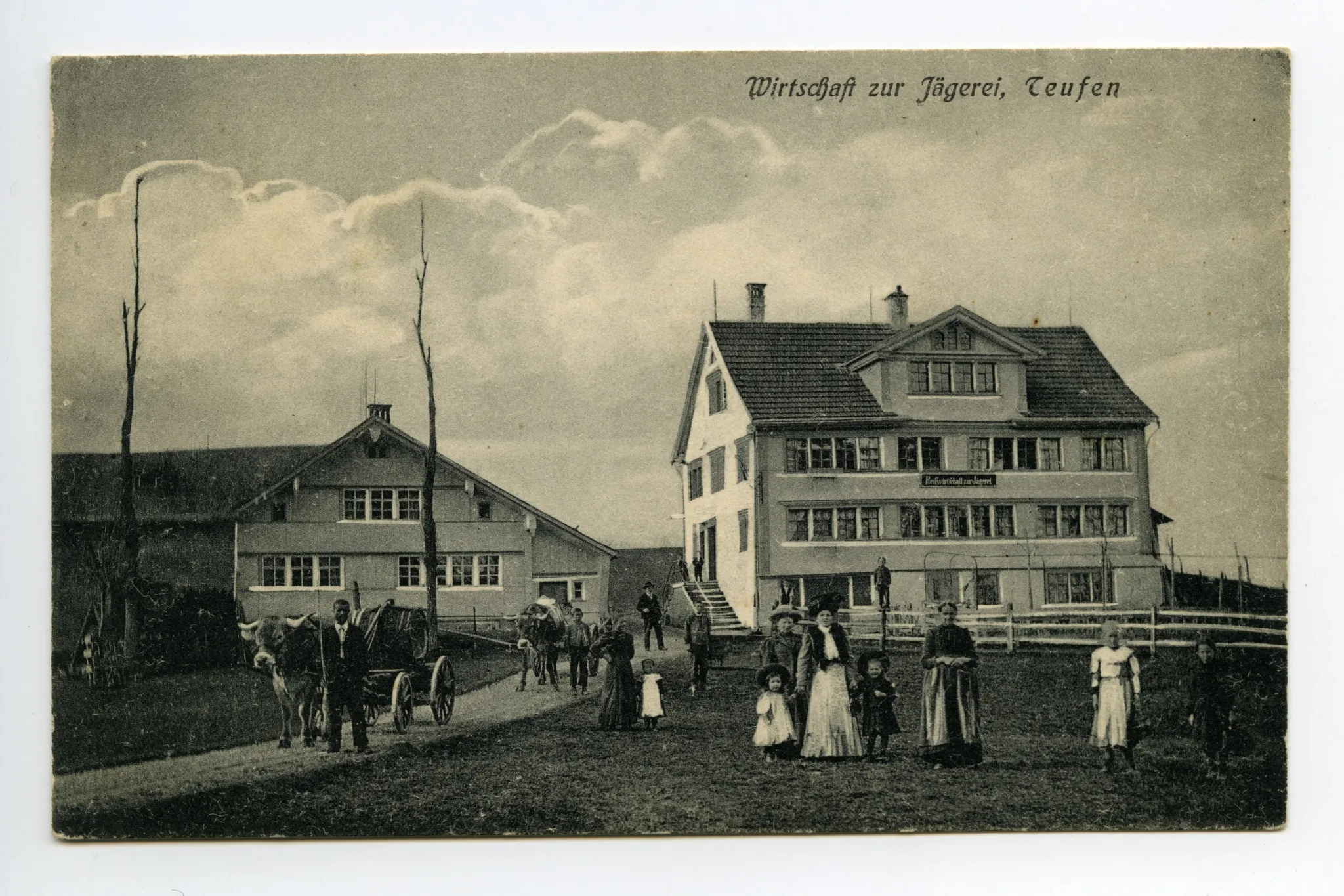 Ansicht aus Süden mit Personen vor der Wirtschaft und Ochsenfuhrwerke auf der Strasse