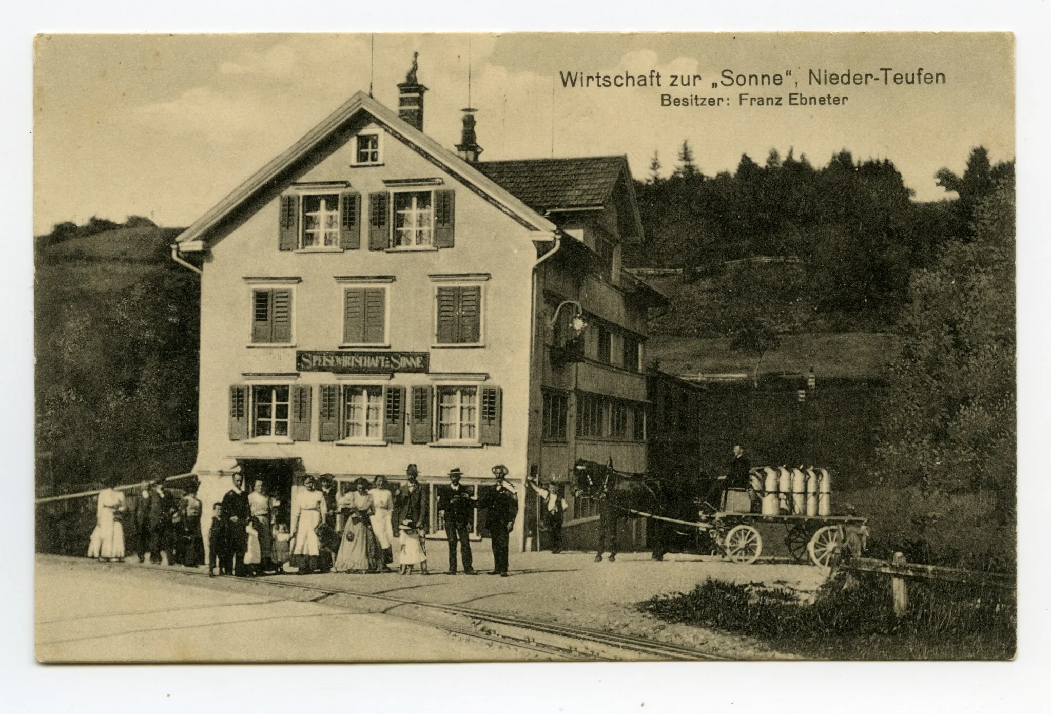 (abgebrannt 1917), Ansicht aus Süden mit Personen davor, Pferdefuhrwerk mit Tansen beladen und Bahnschienen im Vordergrund