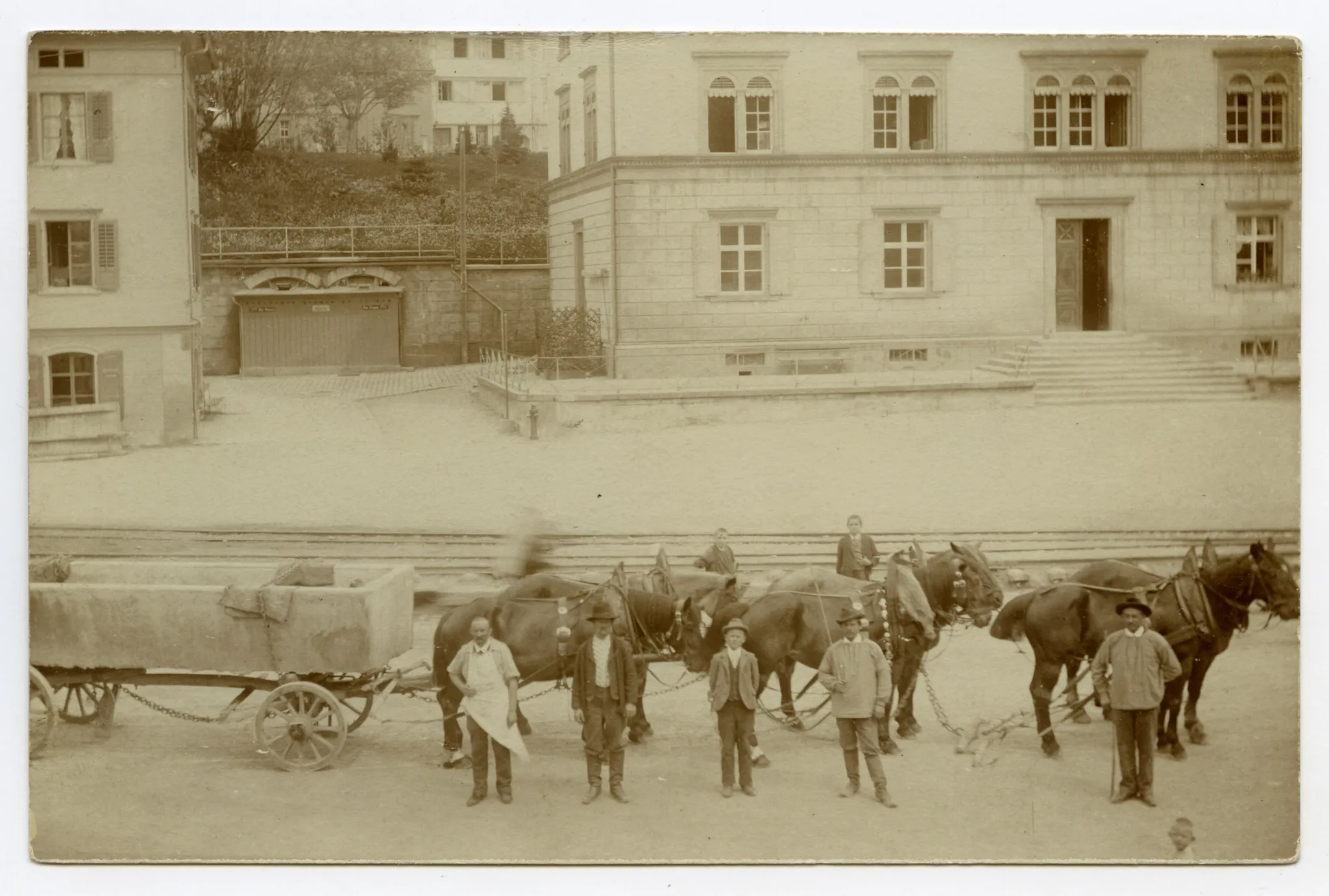 Sechser, mit Personen, Transport eines Brunnens (ev. Dorfbrunnen), Ansicht vor Dorschulhaus (Haus angeschnitten)