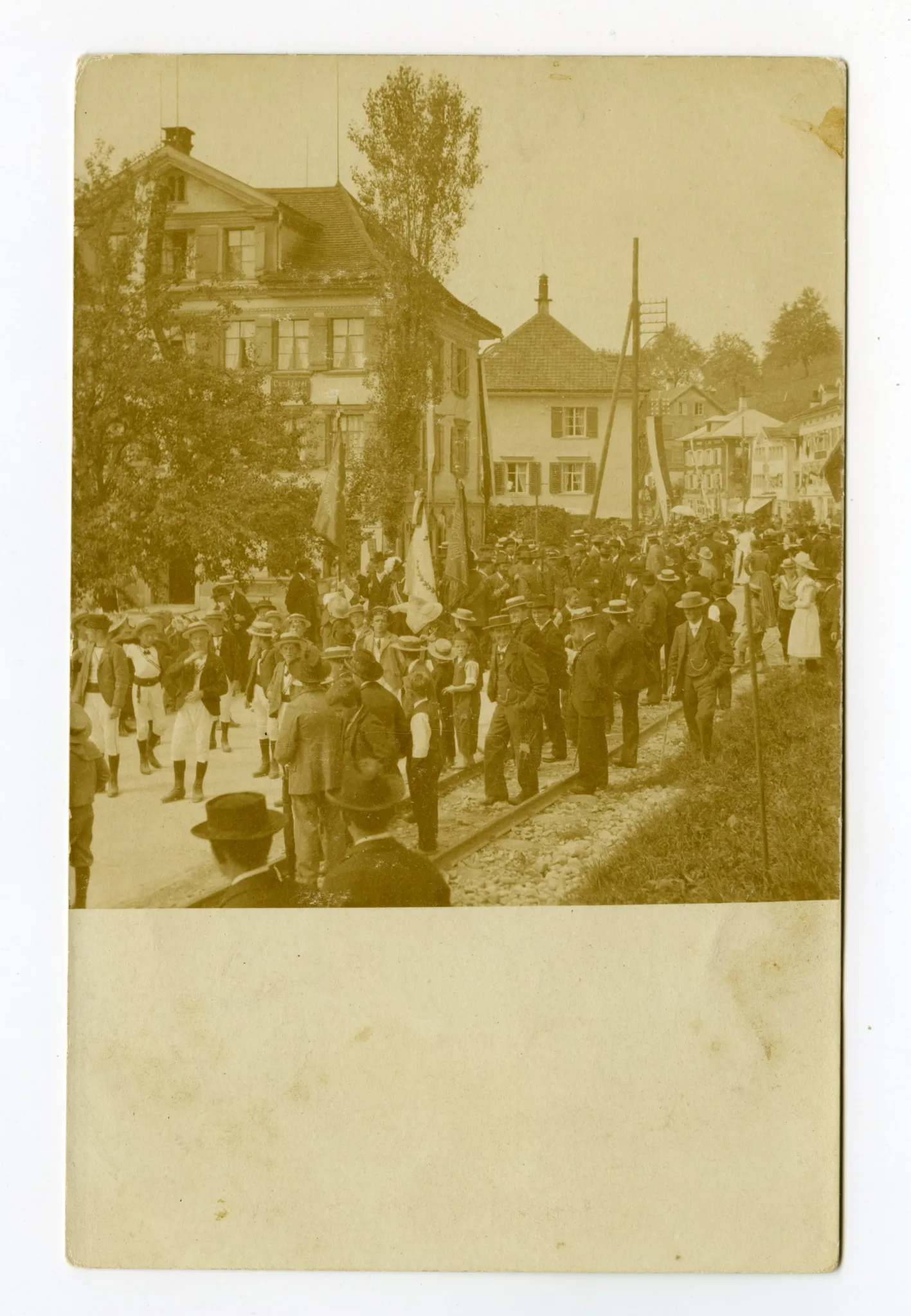 an der Hauptstrasse entlang, Bahnschienen sichtbar, im Hintergrund Gasthaus Ochsen
