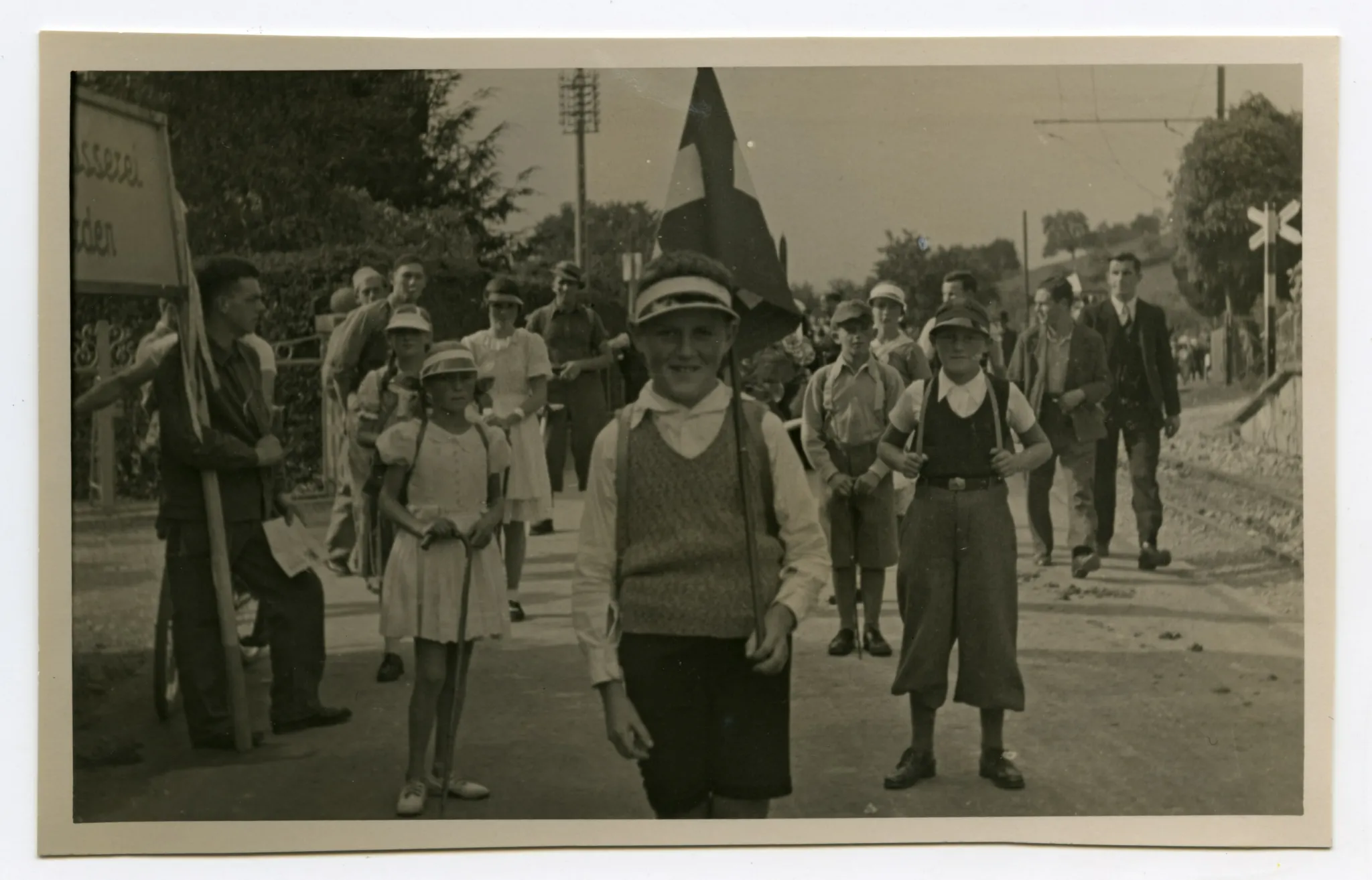 Gruppe von Kindern mit Wanderstöcken und Rücksäcken in Sportbekleidung