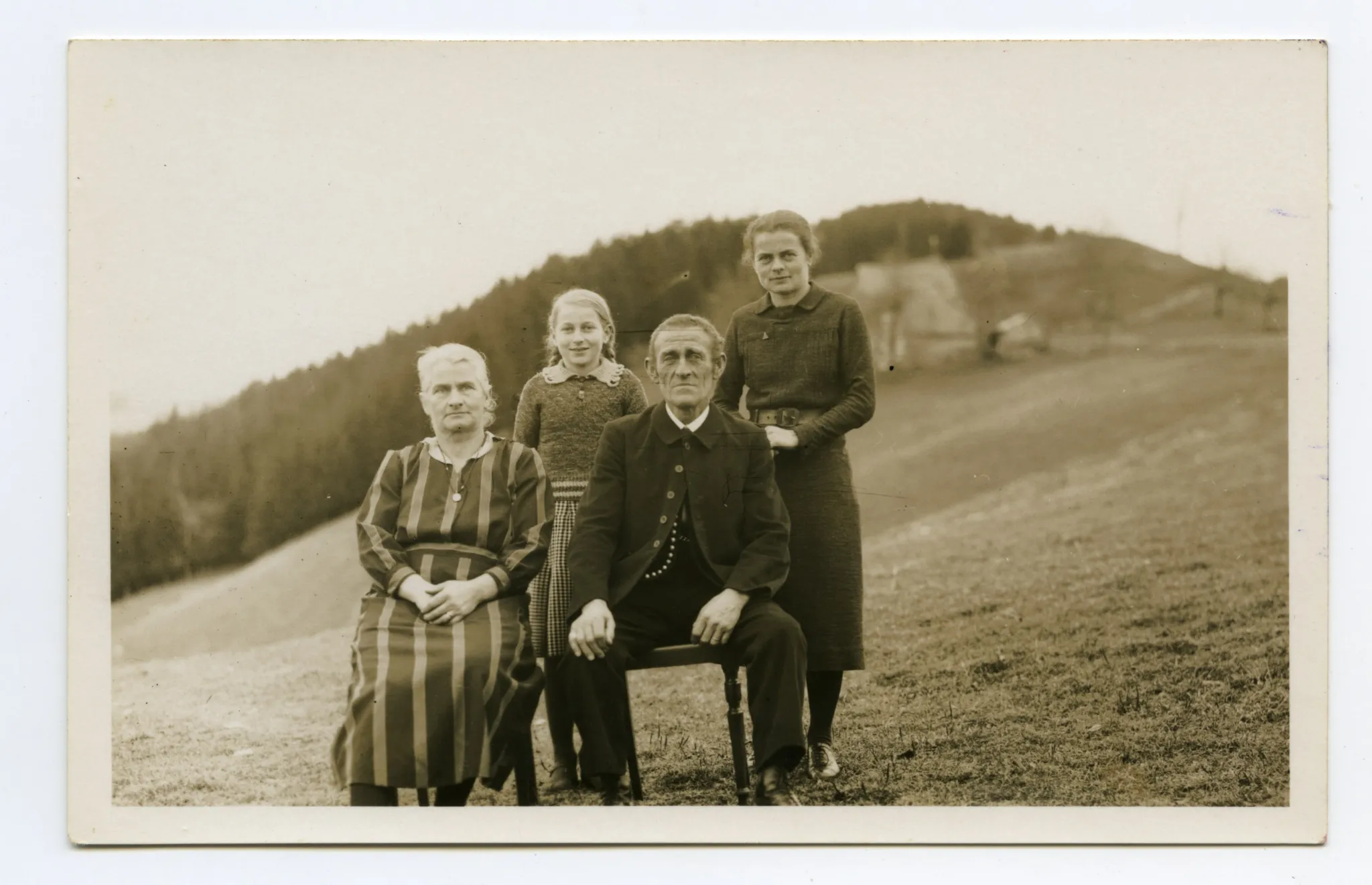 Familienfoto mit Vater, Mutter und zwei Töchtern auf der Wiese