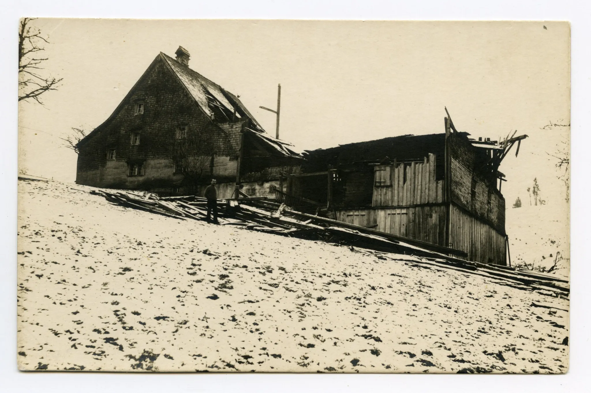 Karte 1: Haus Scheuss mit zerstörter Scheune; Karte 2: Winter, Haus Scheuss, Rückseite mit zerstörter Scheune und teilweise zerstörtem Dach des Wohnteils, Person vor dem Haus
