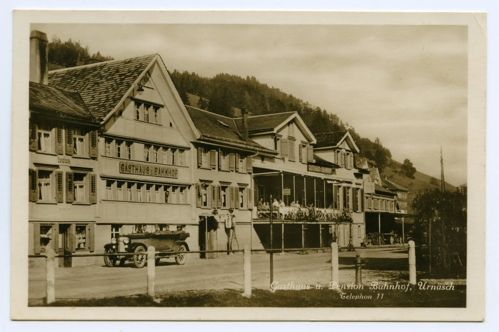 Ansicht Häuserzeile mit Gasthaus und Pension Bahnhof, mit Automobil vor dem Gasthaus