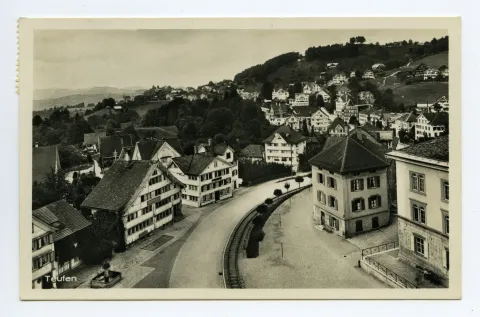 Dorfschulhaus (z.T.), Alter Bahnhof, Gasthaus „Bahnhof“ mit Brückenwaage, alter Dorfbrunnen, Konsum-Verein. Blick Richtung Stofel / Eggli, Frohe Aussicht (vgl. Hc.20.19, Kartenauflage b statt g)