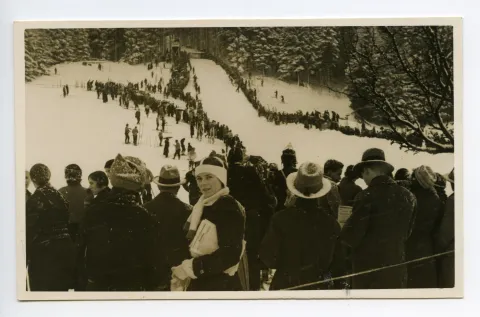 Winter, Skifahrer und Zuschauer säumen die Schanze