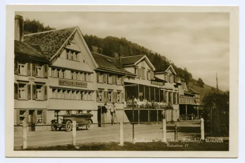 Ansicht Häuserzeile mit Gasthaus und Pension Bahnhof, mit Automobil vor dem Gasthaus